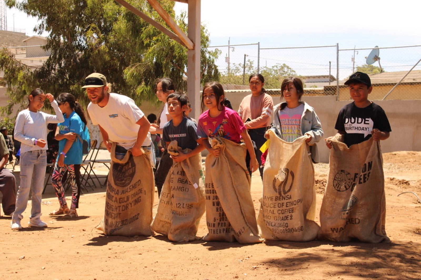 Kids laughing during a sack race at a Buena Onda after-school event