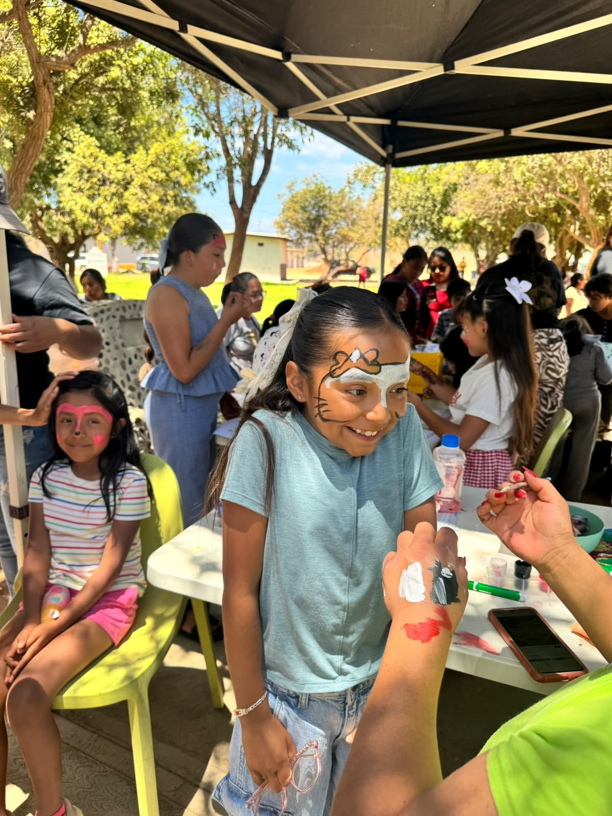 A child smiling with face paint at an IThinkBig community event